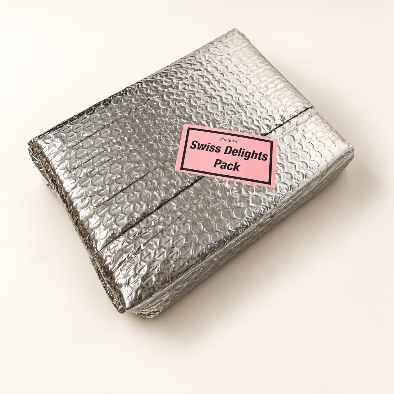 Swiss Delights cheese parcel wrapped in silver bubble insulation with a pink Swiss Delights Pack label.